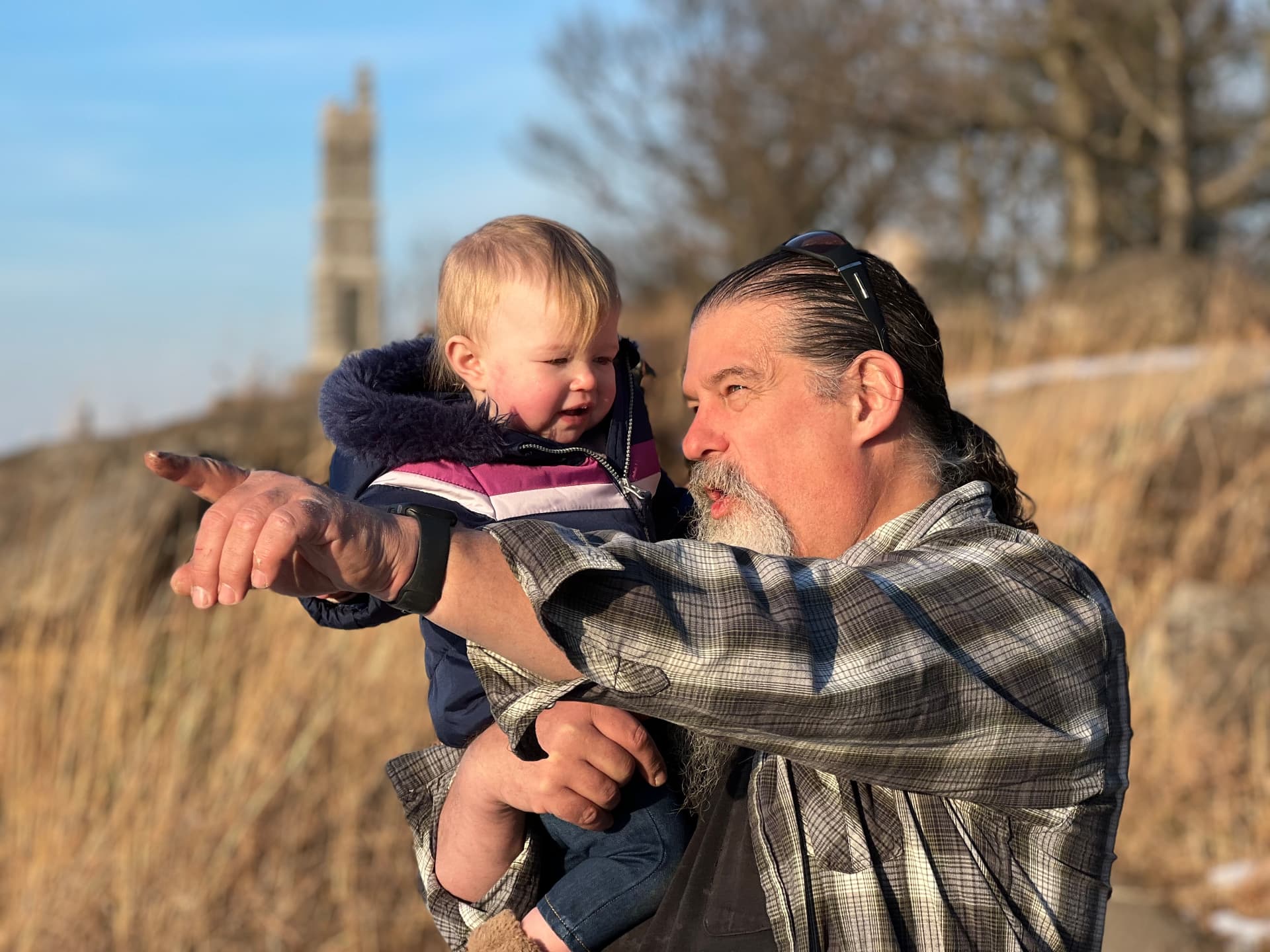 Vernon Hyndman pointing out something to a child in golden-hour light